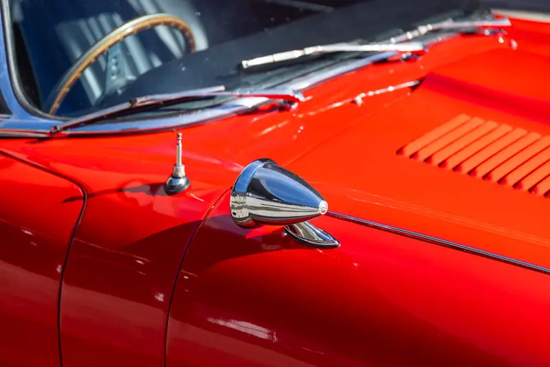 Red classic car with chrome wing mirror